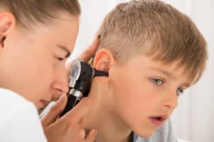 doctor checking child patient's ear