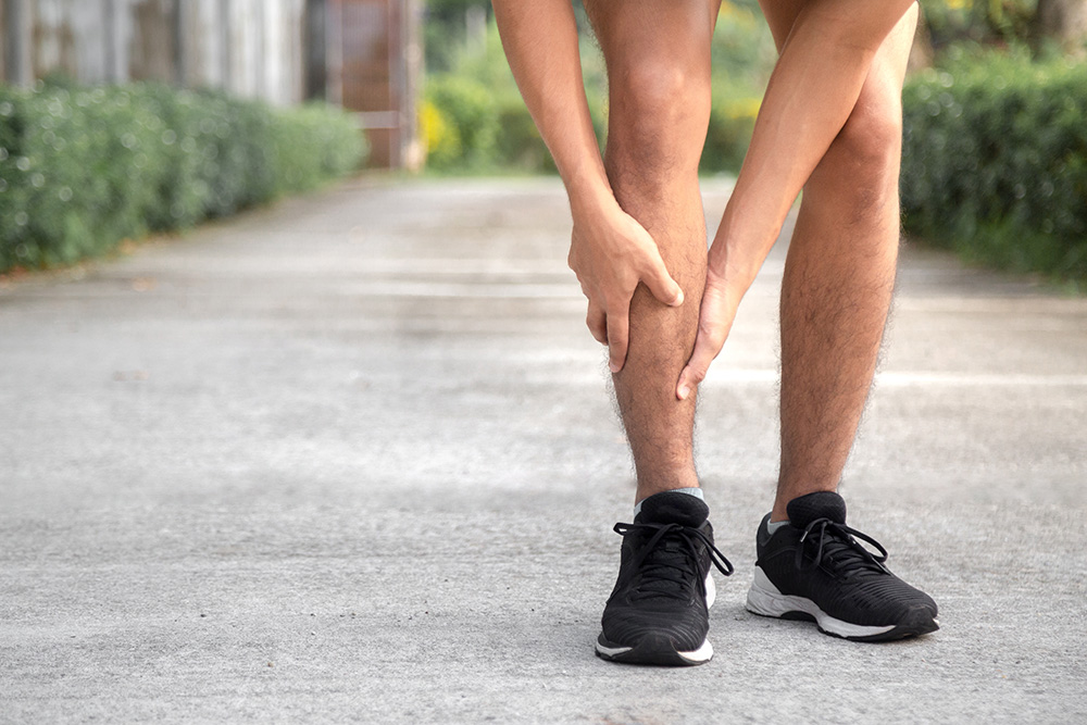 Runner holding shin in pain from shin splints.